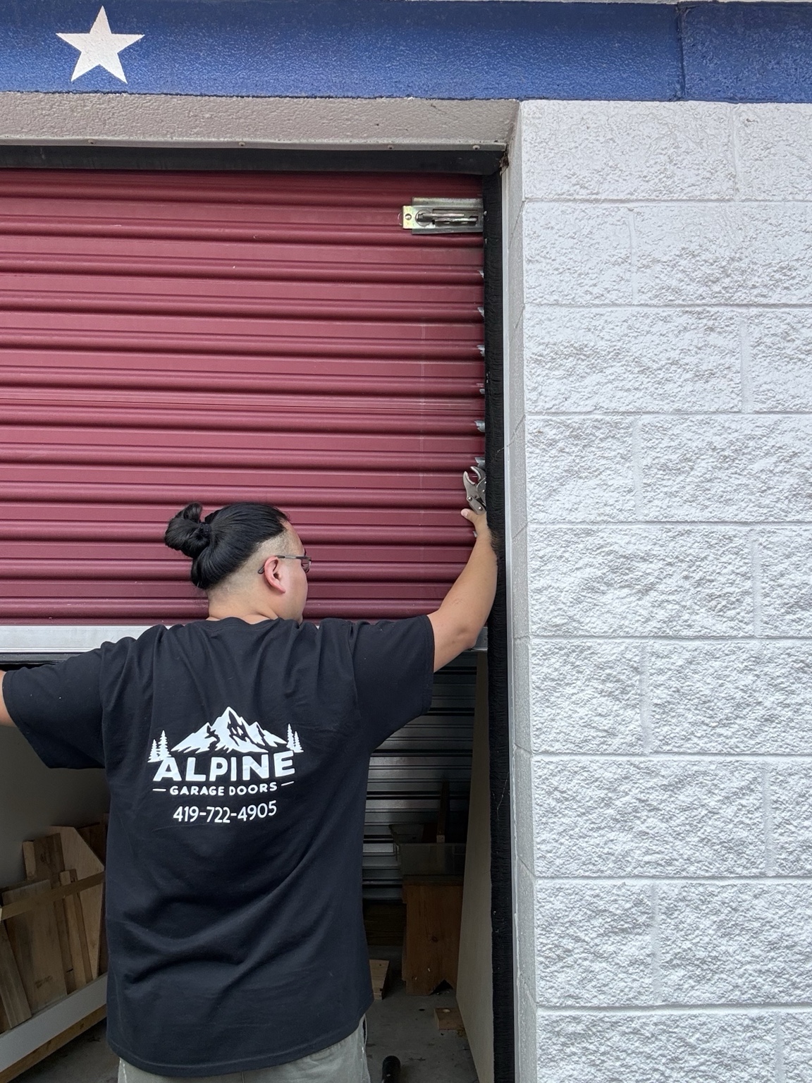 Daniel inspecting a red commercial rolling door