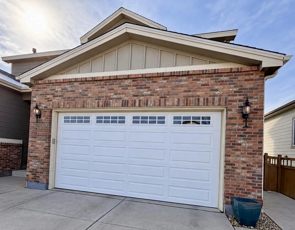 White windowed garage door framed by brick