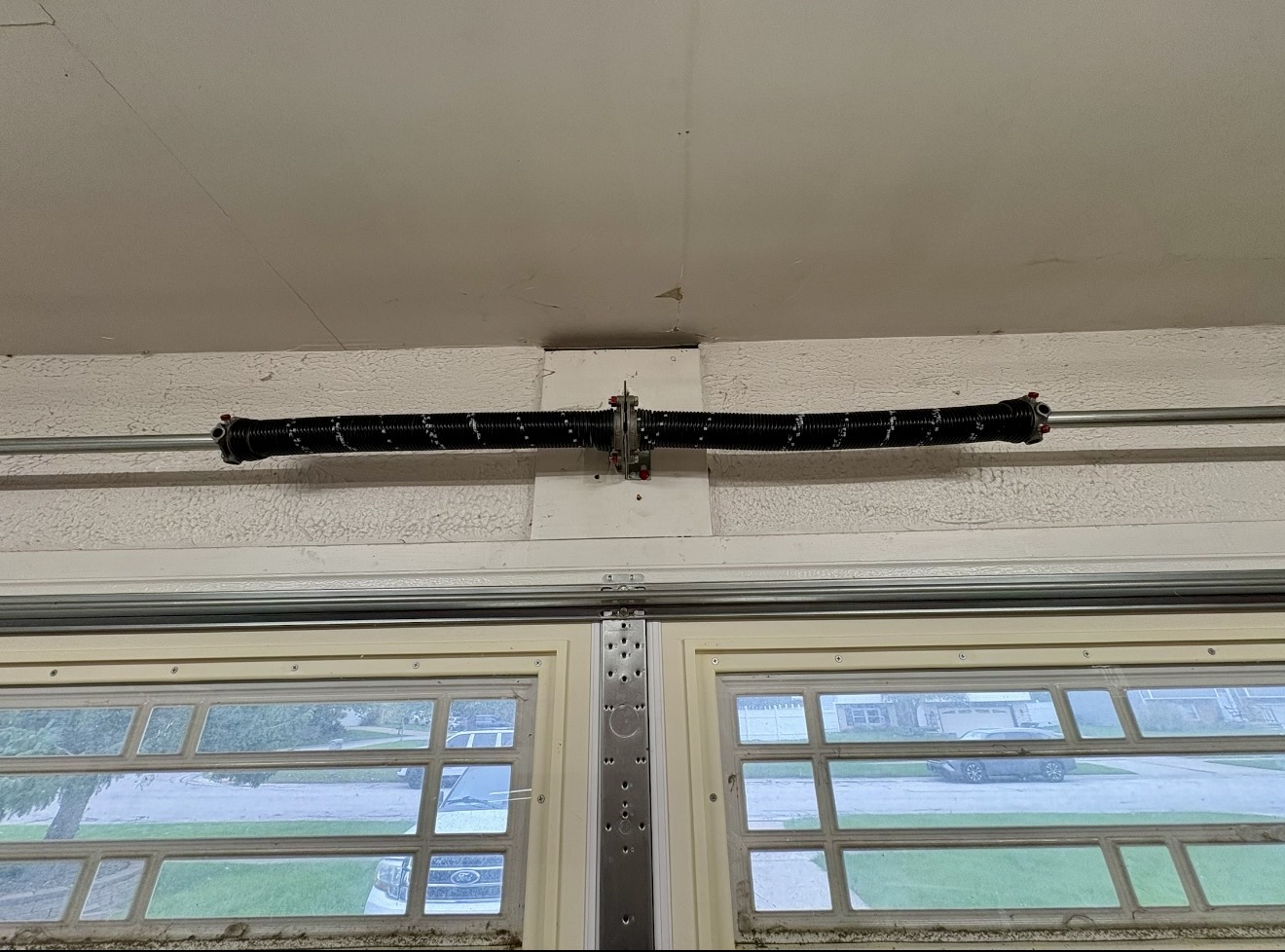 Two-spring torsion system installed above a garage door